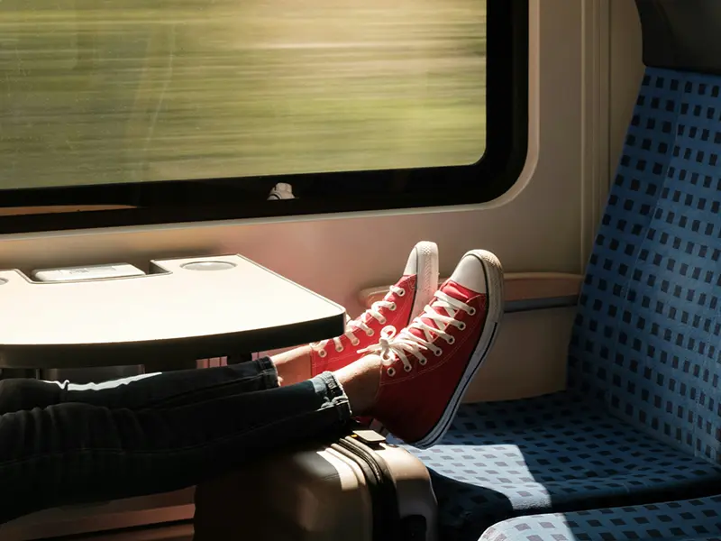 Person mit roten und weißen Sneakern in öffentlichen Verkehrsmitteln.